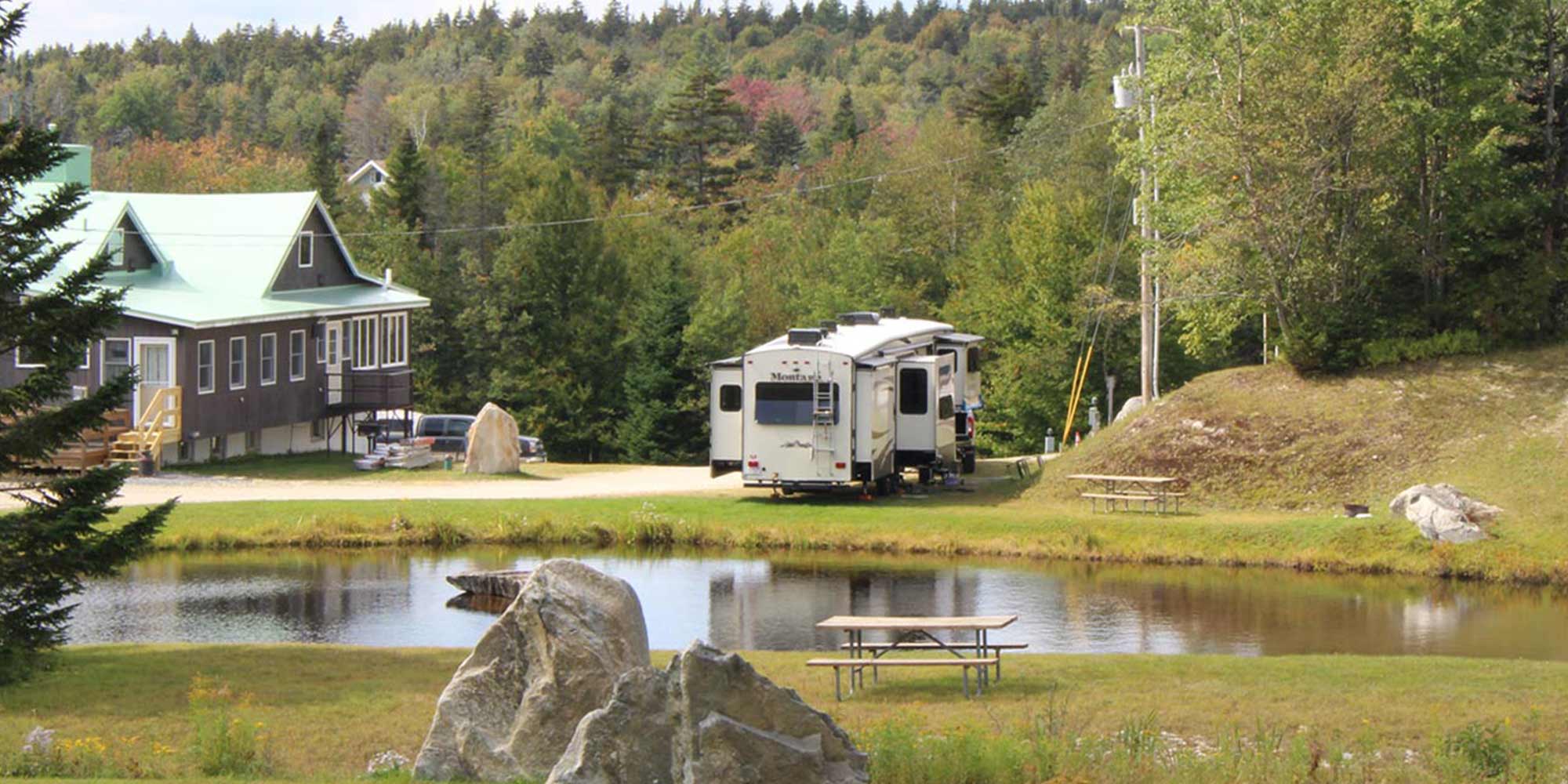 An RV parked near a lake during summer