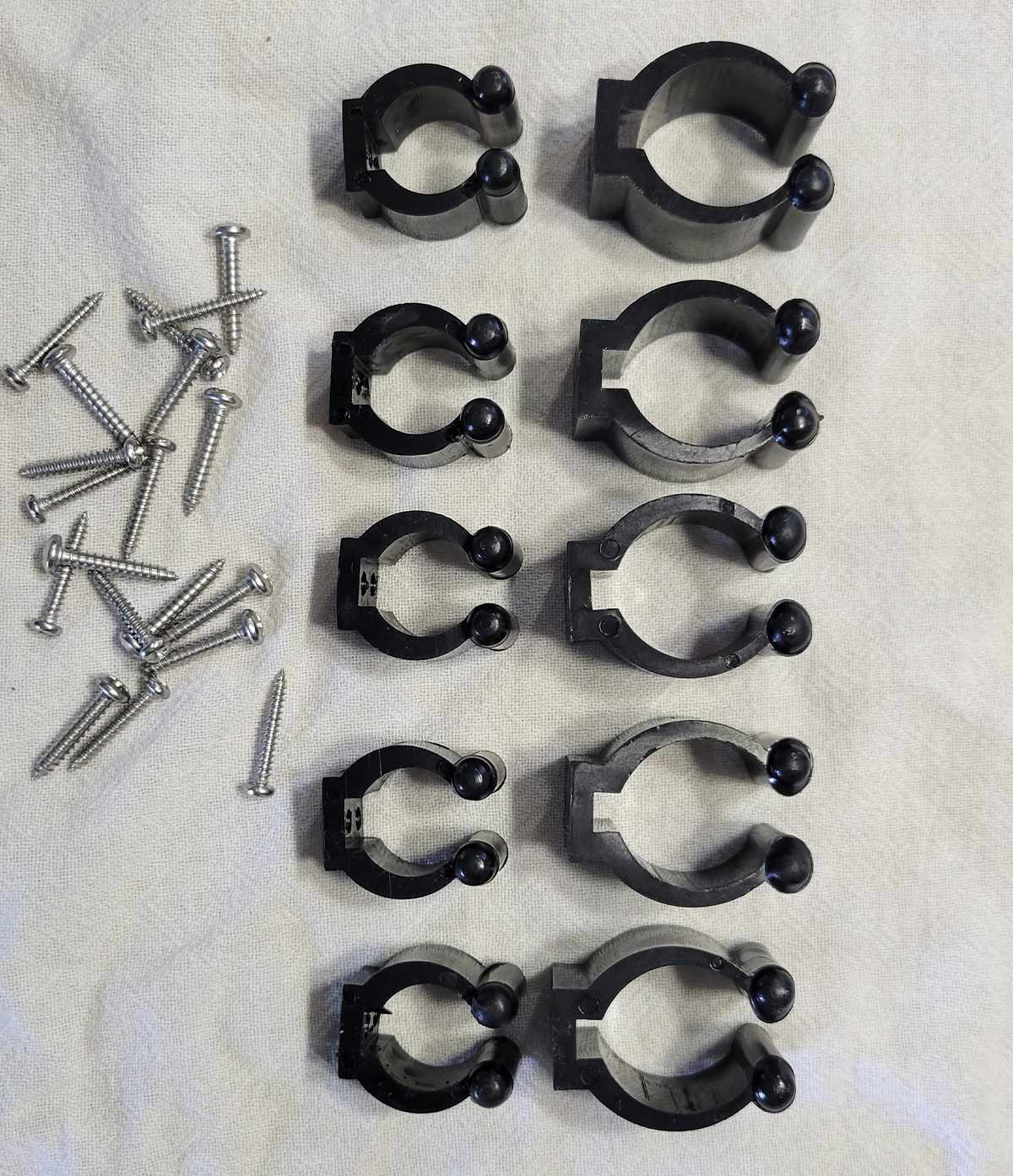 five sets of brackets (clips) and stainless-steel screws laid out