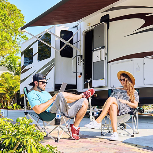 a young couple sitting outside by their RV