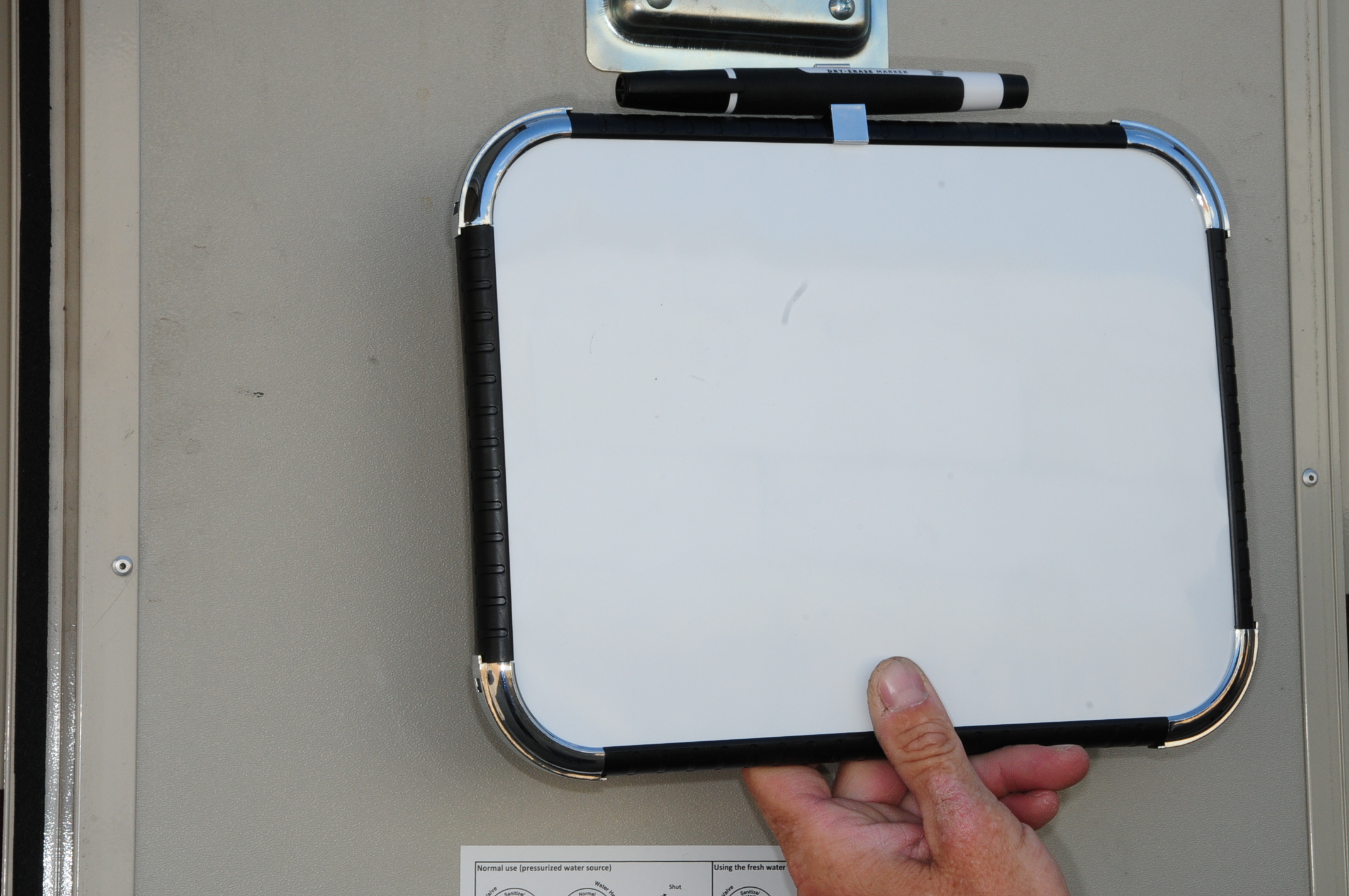 technician holds a 8 ½ x 11 inch white board from Office Depot