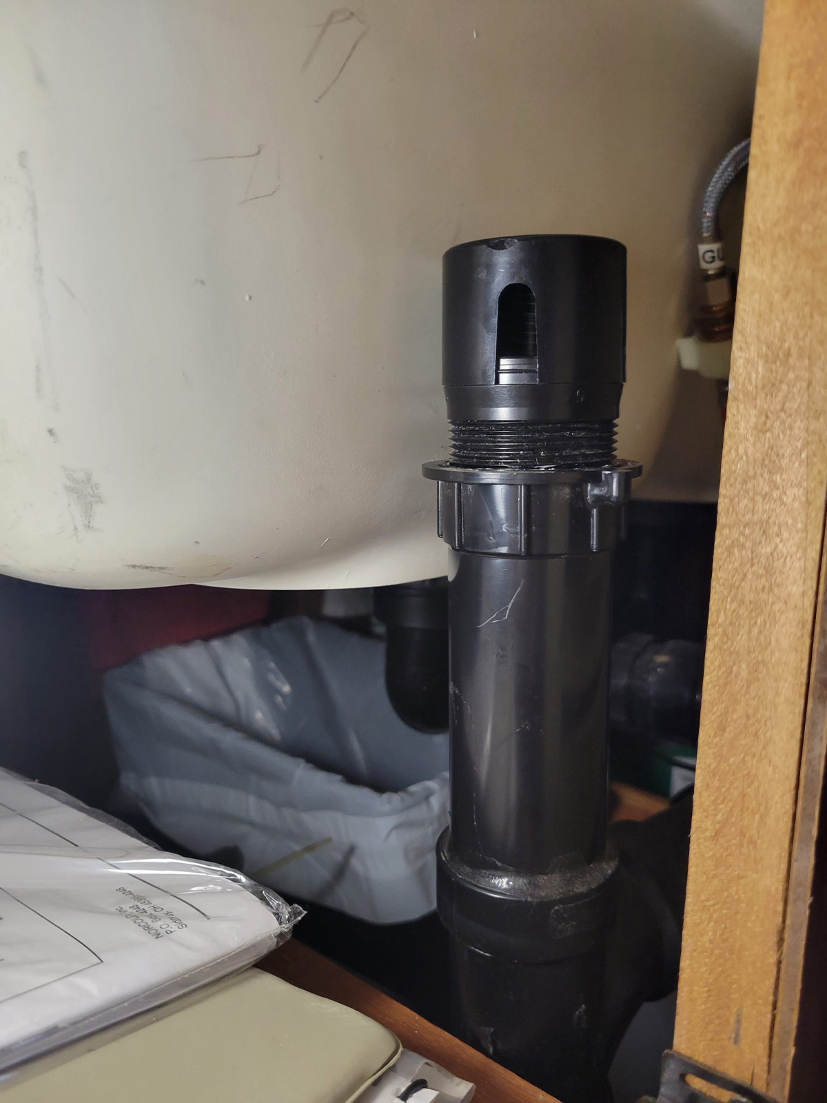 the original check vent, mounted to a pipe next to the P-trap