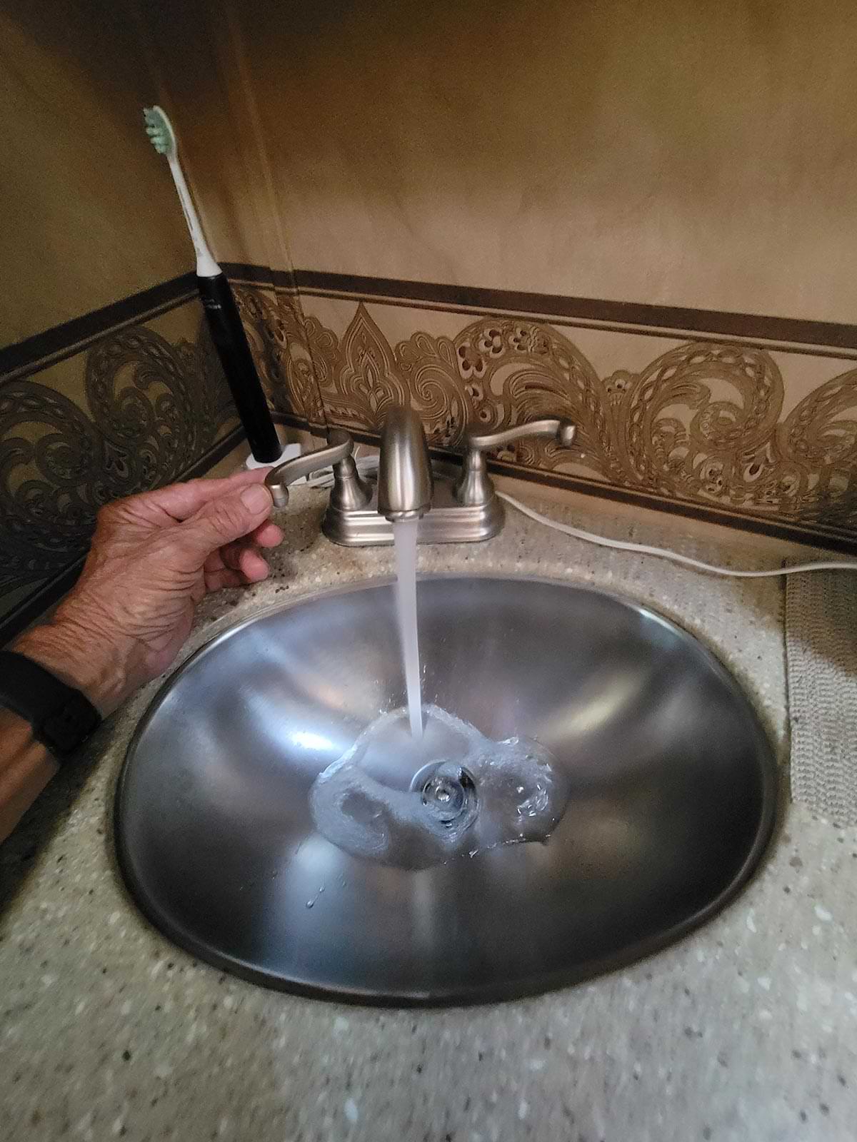a bathroom sink being turned on