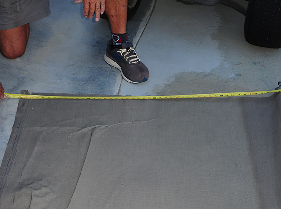 man measuring rv topper fabric