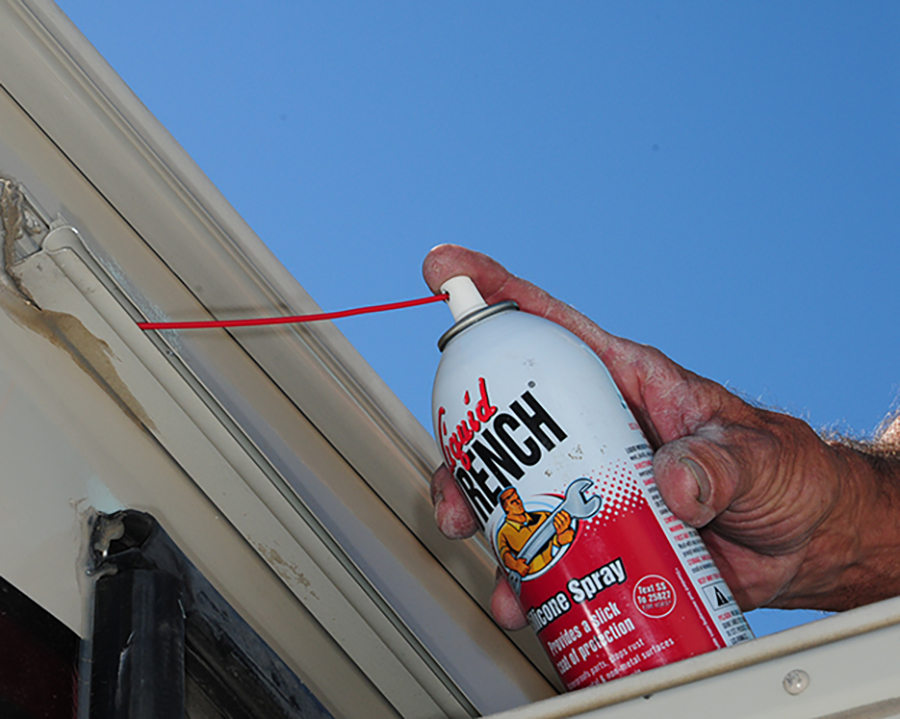 spraying inside of awning rail with silicone