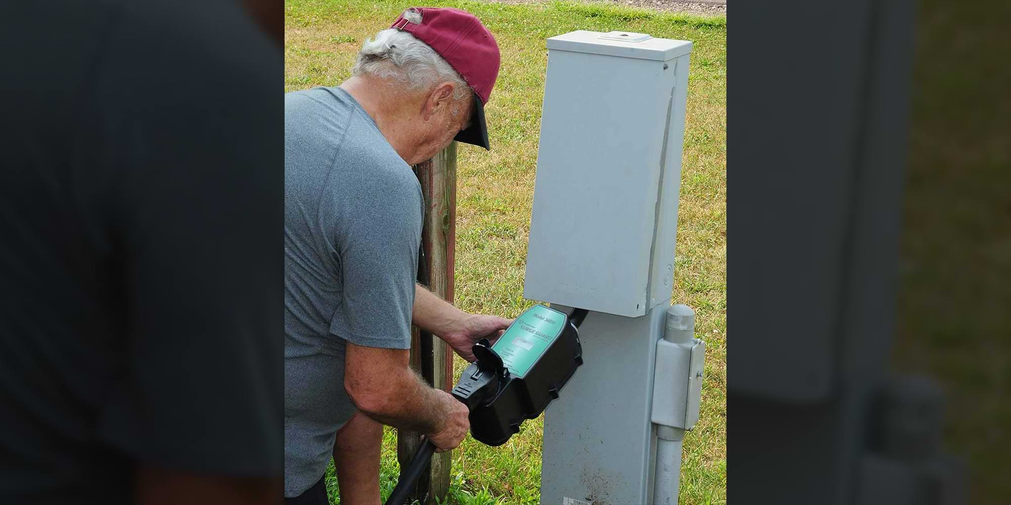 a man uses a surge guard on an outdoor electrical outlet