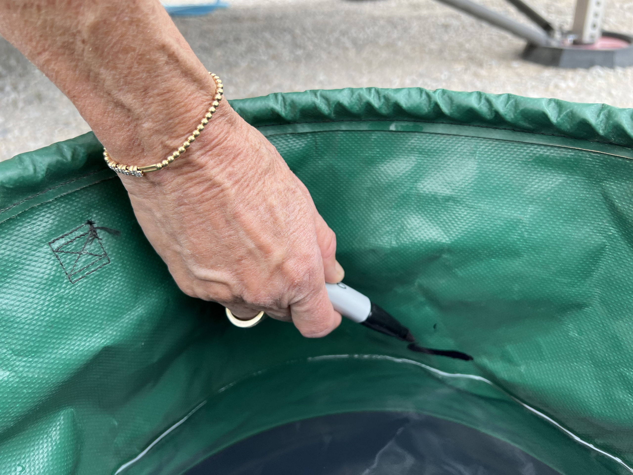 technician uses a sharpie to mark a fill line in the collapsible bucket