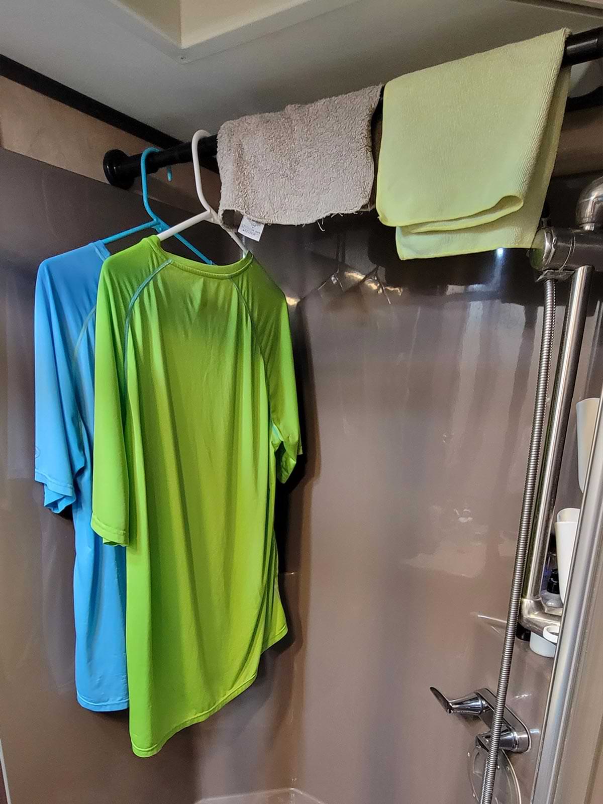 clothes hang from a shower curtain rod in an RV shower