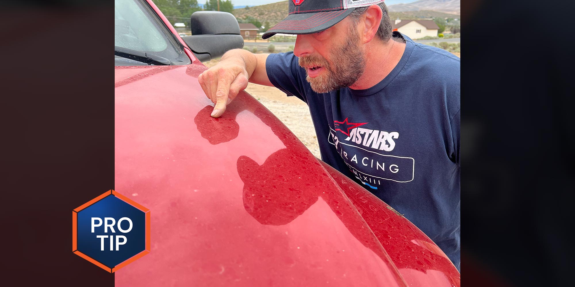 RV technician points to a dirty red car hood