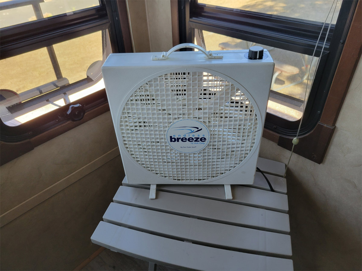 the Endless Breeze fan set up on a table next to the windows of an RV
