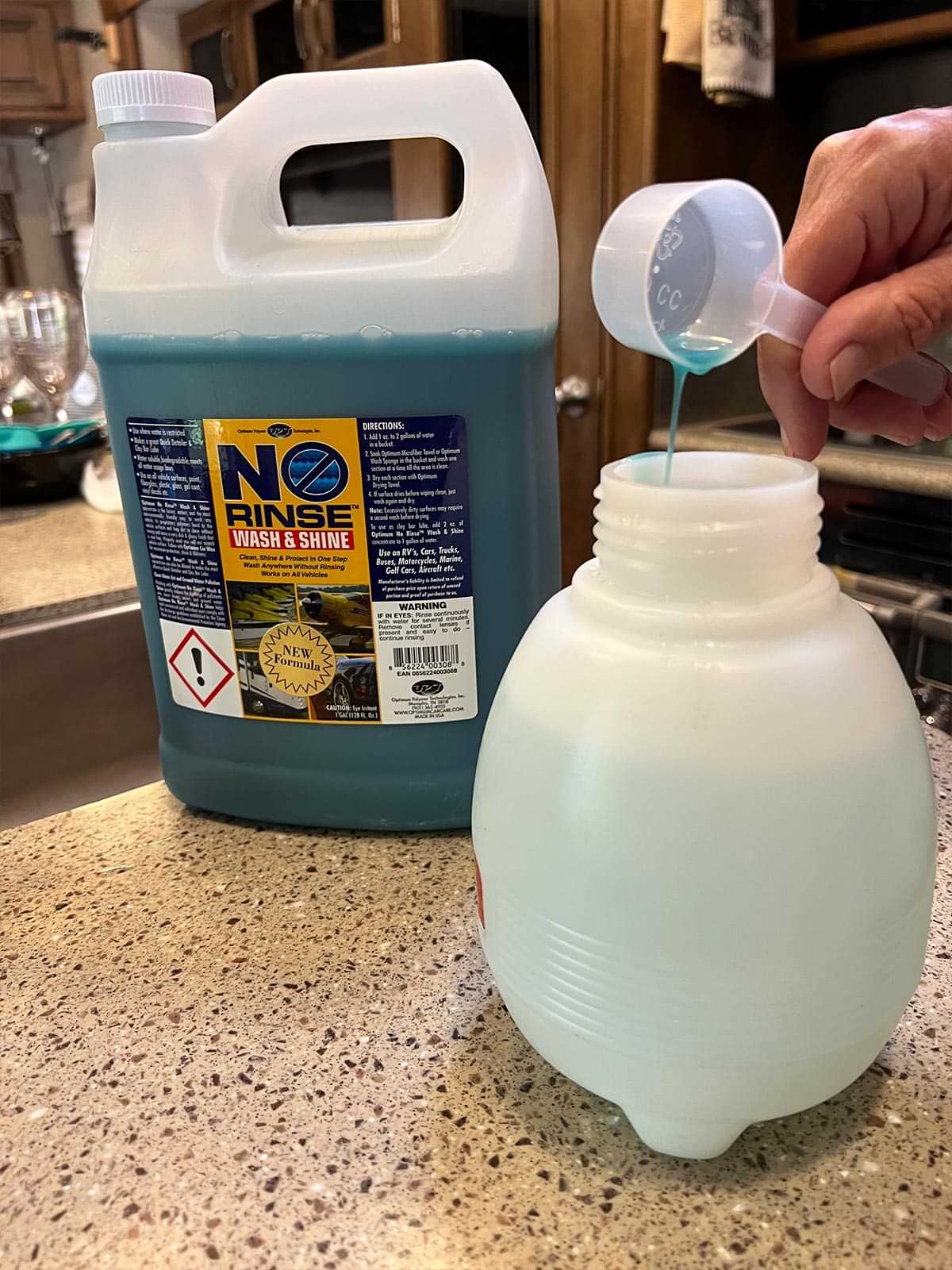 a bottle of No Rinse Wash & Shine sits on a counter as a measuring spoon is used to add the concentrate to the Solo canister