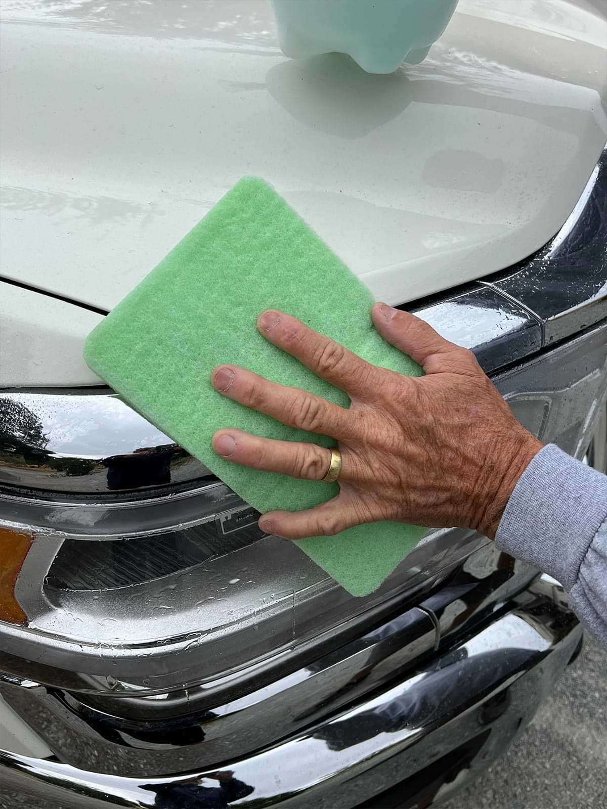 a Boss Love Bug Eraser pad is used to wipe the front grill area of a vehicle
