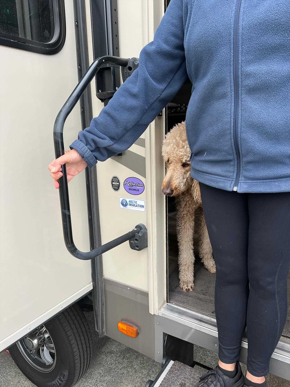 a person stands at the doorway of an RV holding a gripless handle