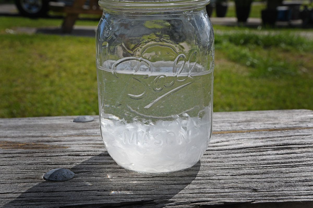 a mason jar filled with water and a single sheet of Thetford’s Aqua Soft toilet paper