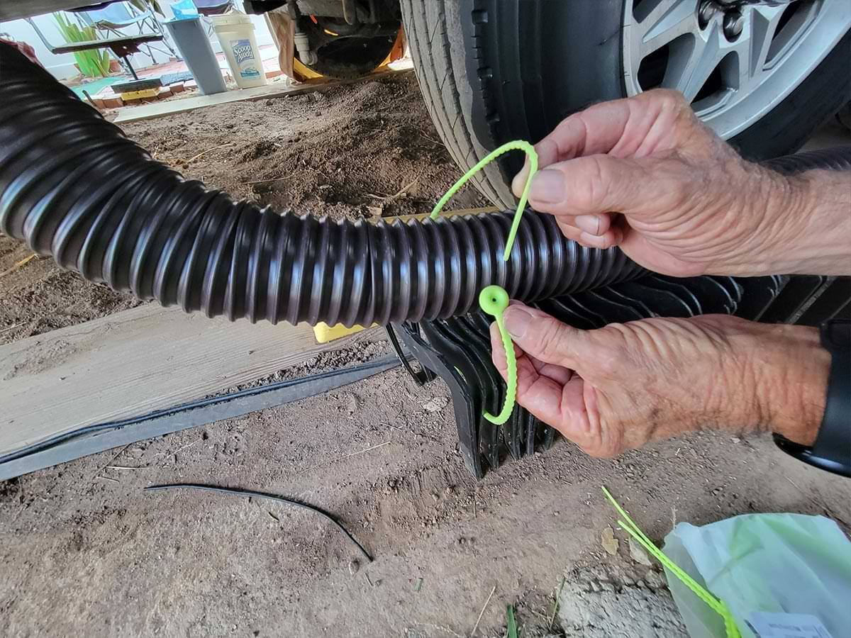 RV technician wraps the hose with a neon green 21 inch silicone zip tie with ease