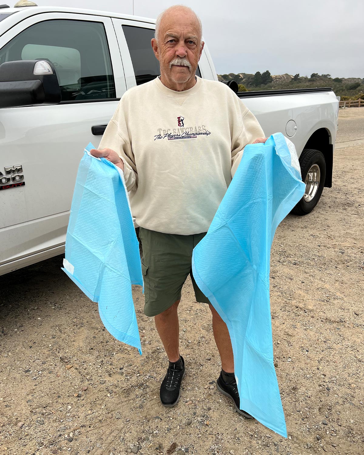 RV technician holds two different sized piddle pads for comparison
