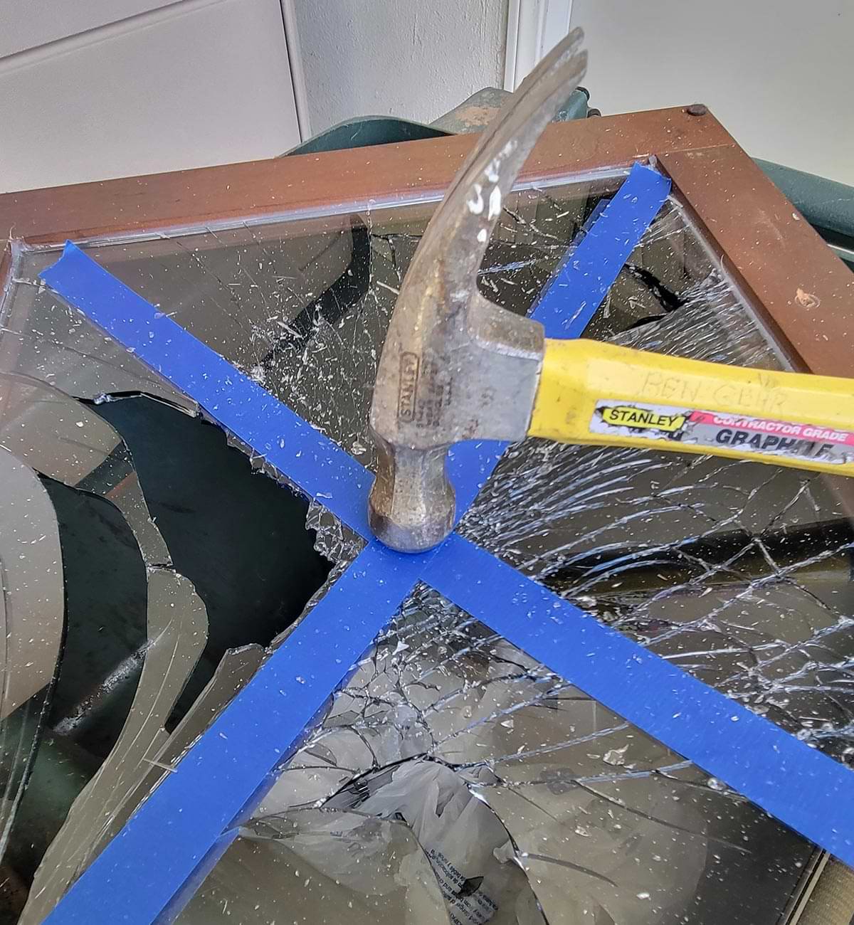 with masking tape on the glass a hammer is used to break the glass apart for removal