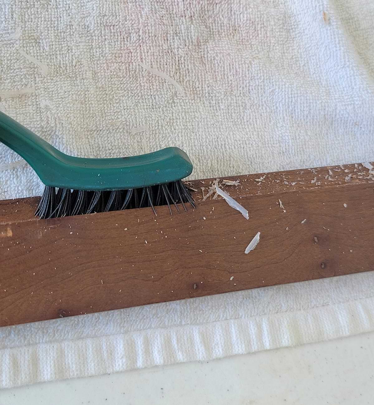 a stiff-bristle brush is used to clean the remaining silicone sealant and any glass chards that were sticking to the frame