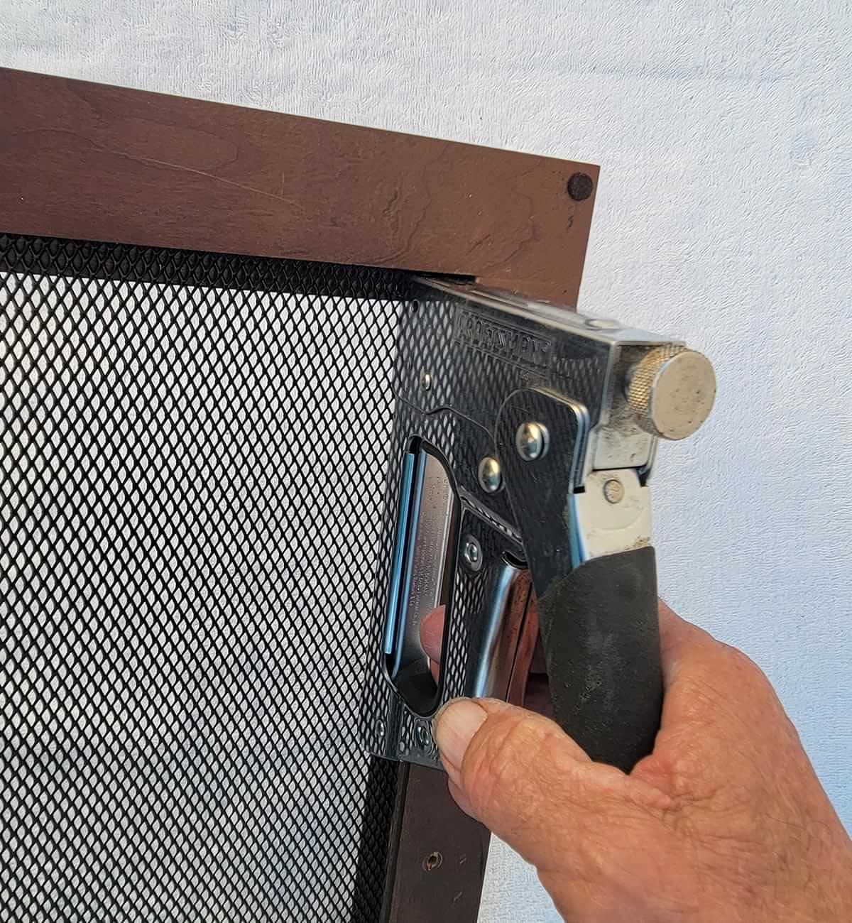 with a strong staple gun, the aluminum mesh screen is affixed to the inside of the compartment door
