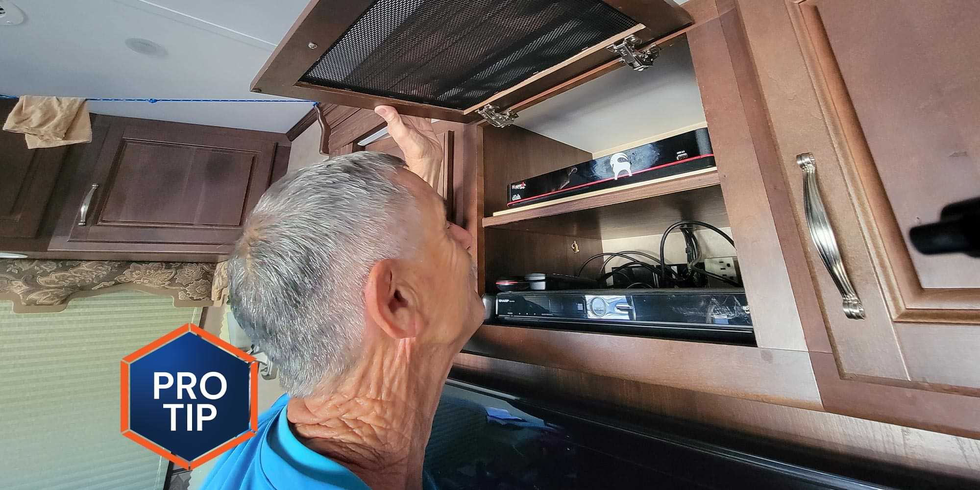 a man looks into an overhead compartment that holds electronic components