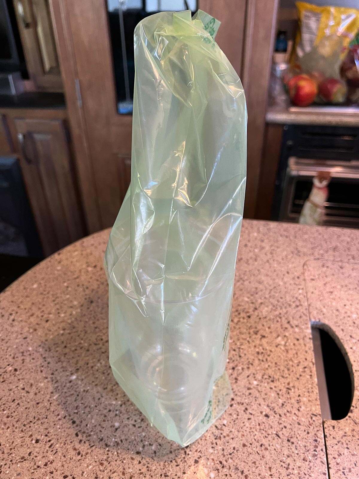 an inside out Debbie Meyer Green Bag is placed over a tall cup to allow the bag to air dry