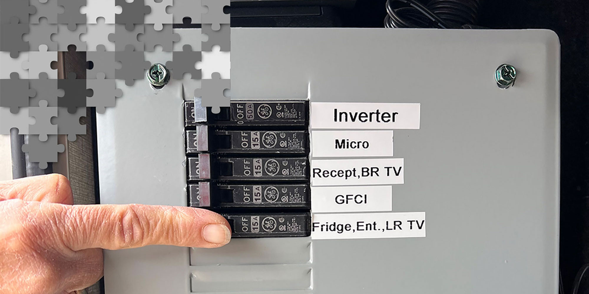 a finger points to a tab on a fuse box