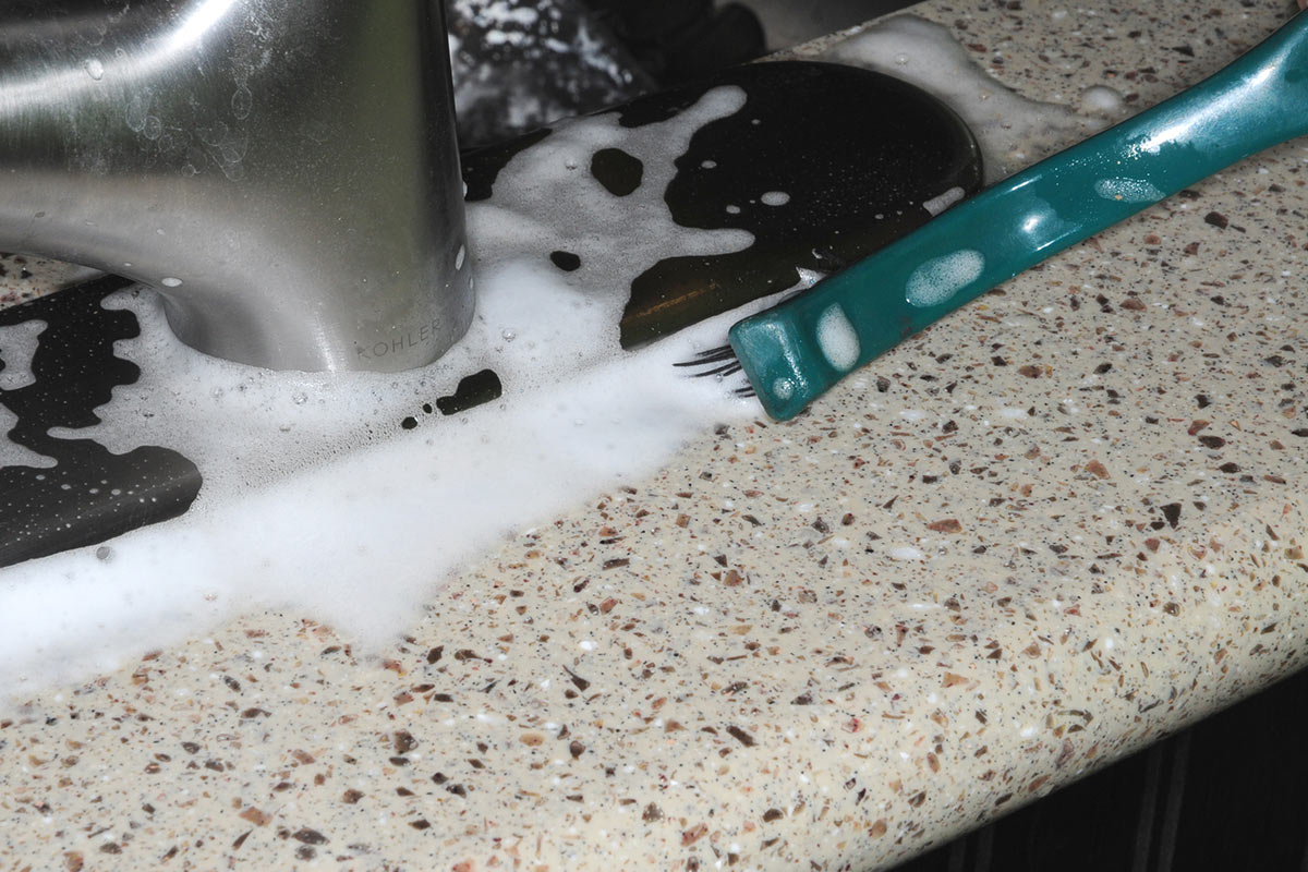 Foaming Action Lime-A-Way and a stiff-bristle nylon brush are used to clean away the calcium that had built up around the base of the faucet