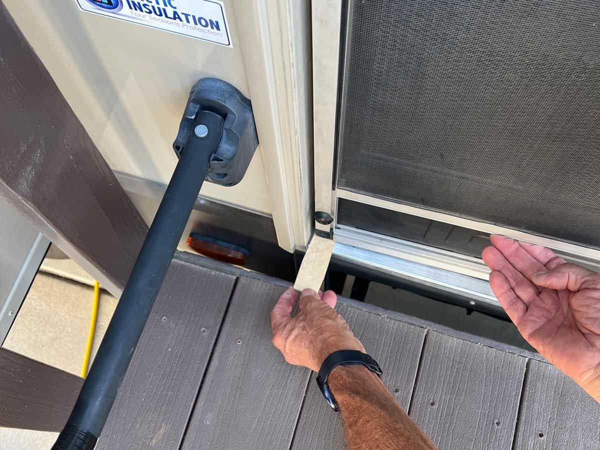 a wedge is placed between the threshold and bottom of the screen door to keep it in position