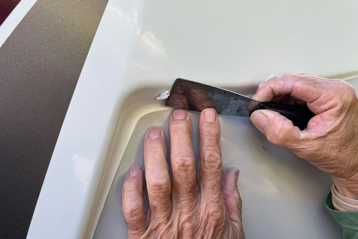 a putty knife is used to push the epoxy into the hole and to cut off the excess