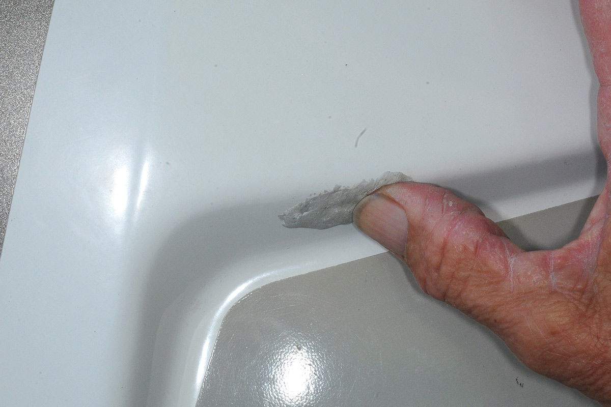 a thumb is used to blend the epoxy into the surrounding fiberglass