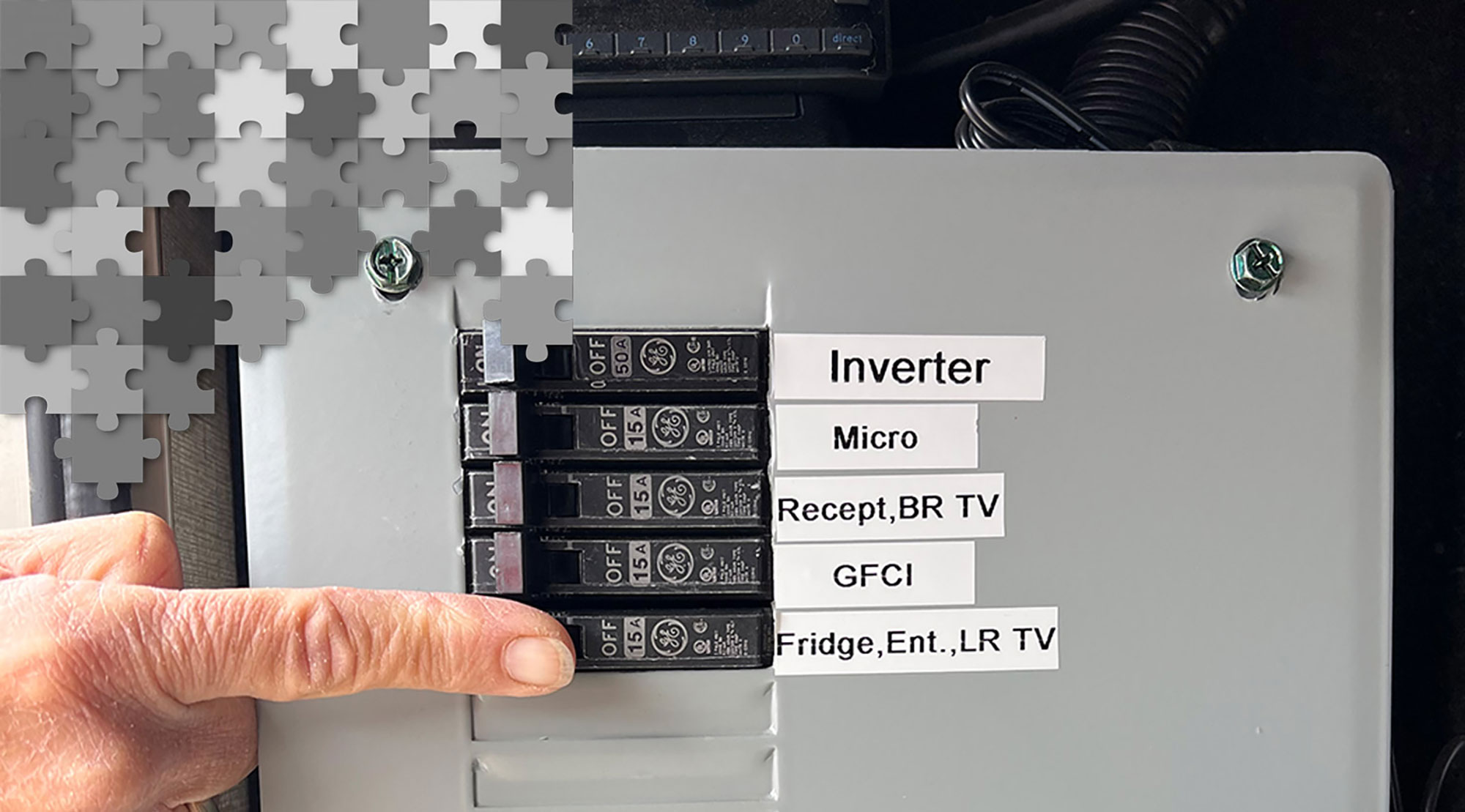 a finger points to a tab on a fuse box