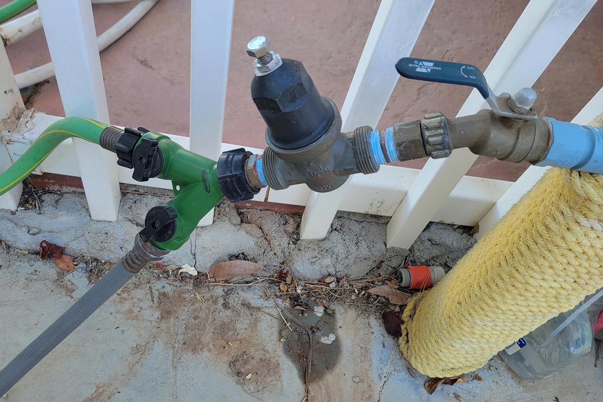 a water pressure regulator connected to a hookup spigot