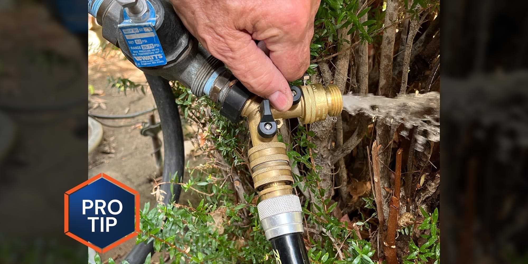 close view of a wye hose head on an outdoor faucet releasing water