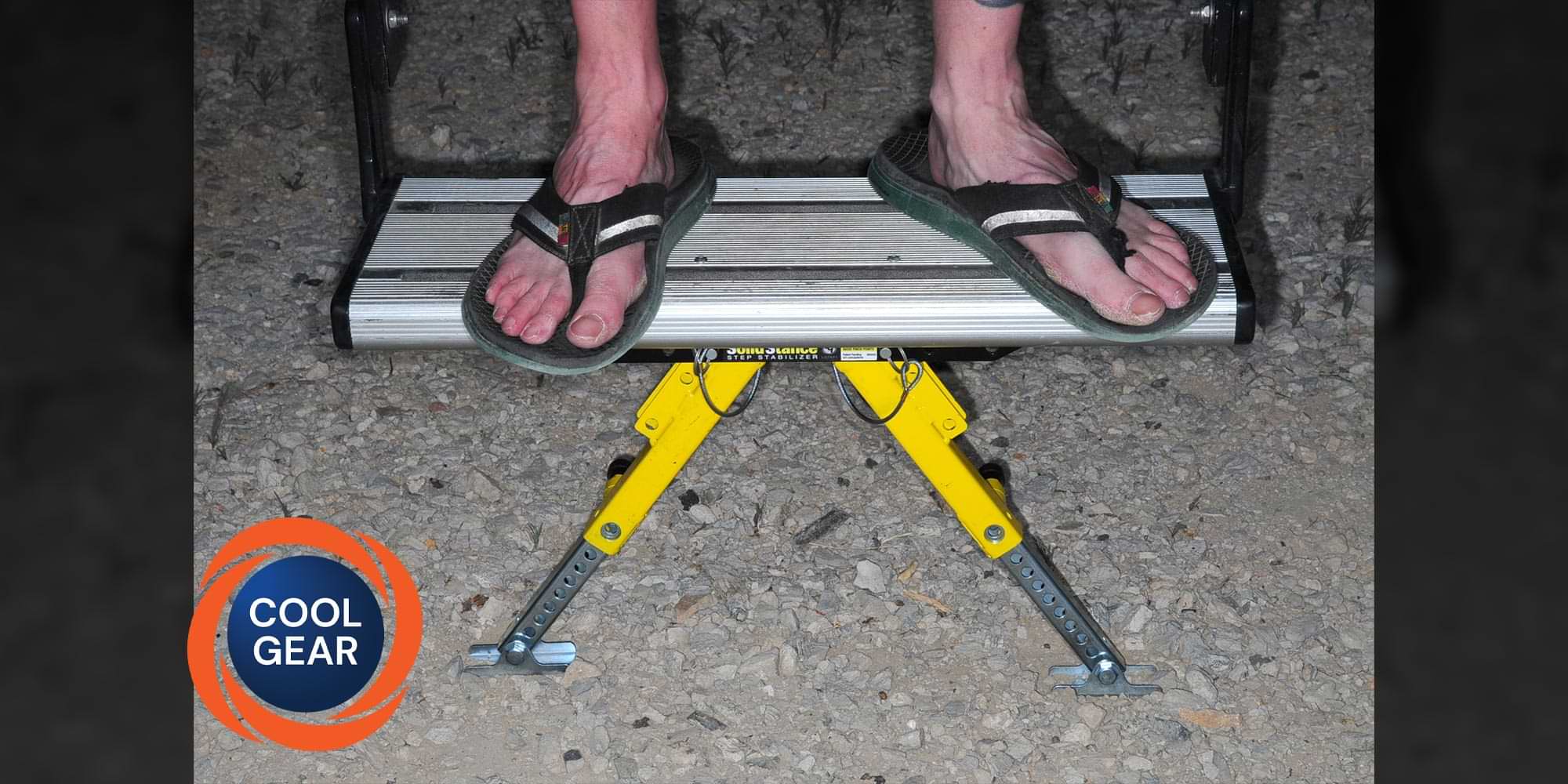 feet in flip flops stand on the last step of an RV entry way, the last step being supported by Lippert's SolidStance Step Stabilizer