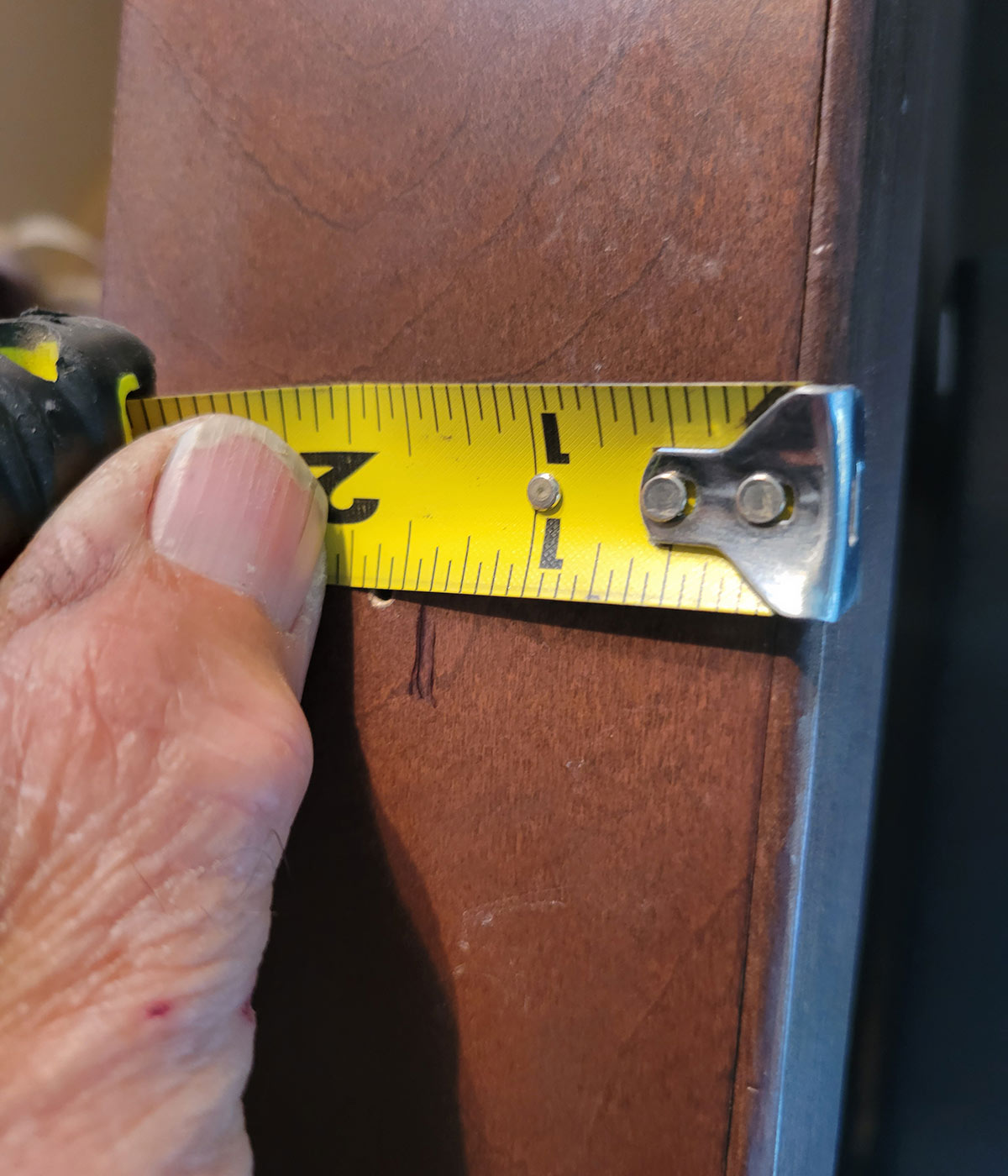 using a measuring tape, measurements are taken to locate the mounting of the magnetic catches