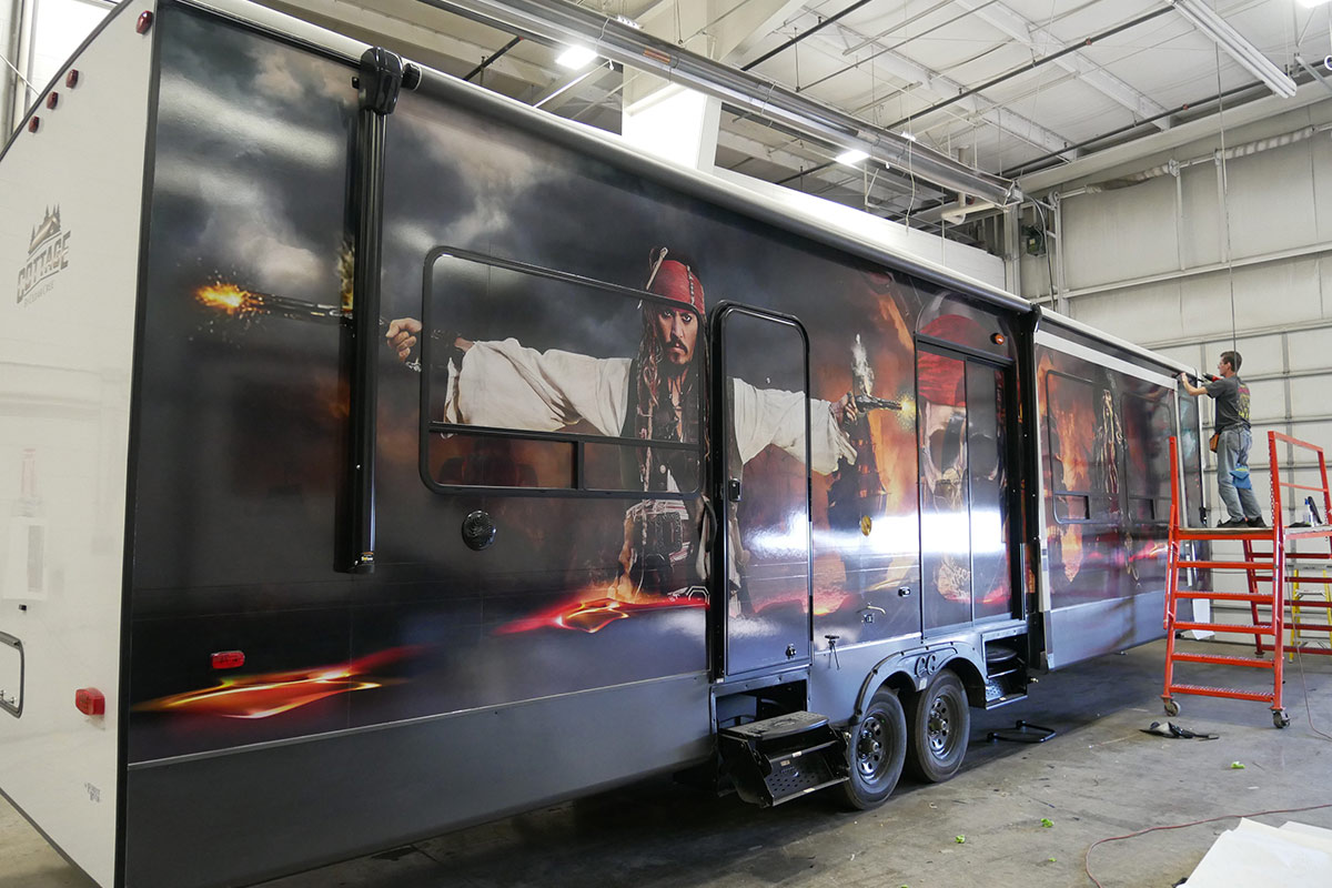 three quarter profile view of an RV wrapped in a Pirates of the Caribbean themed graphic