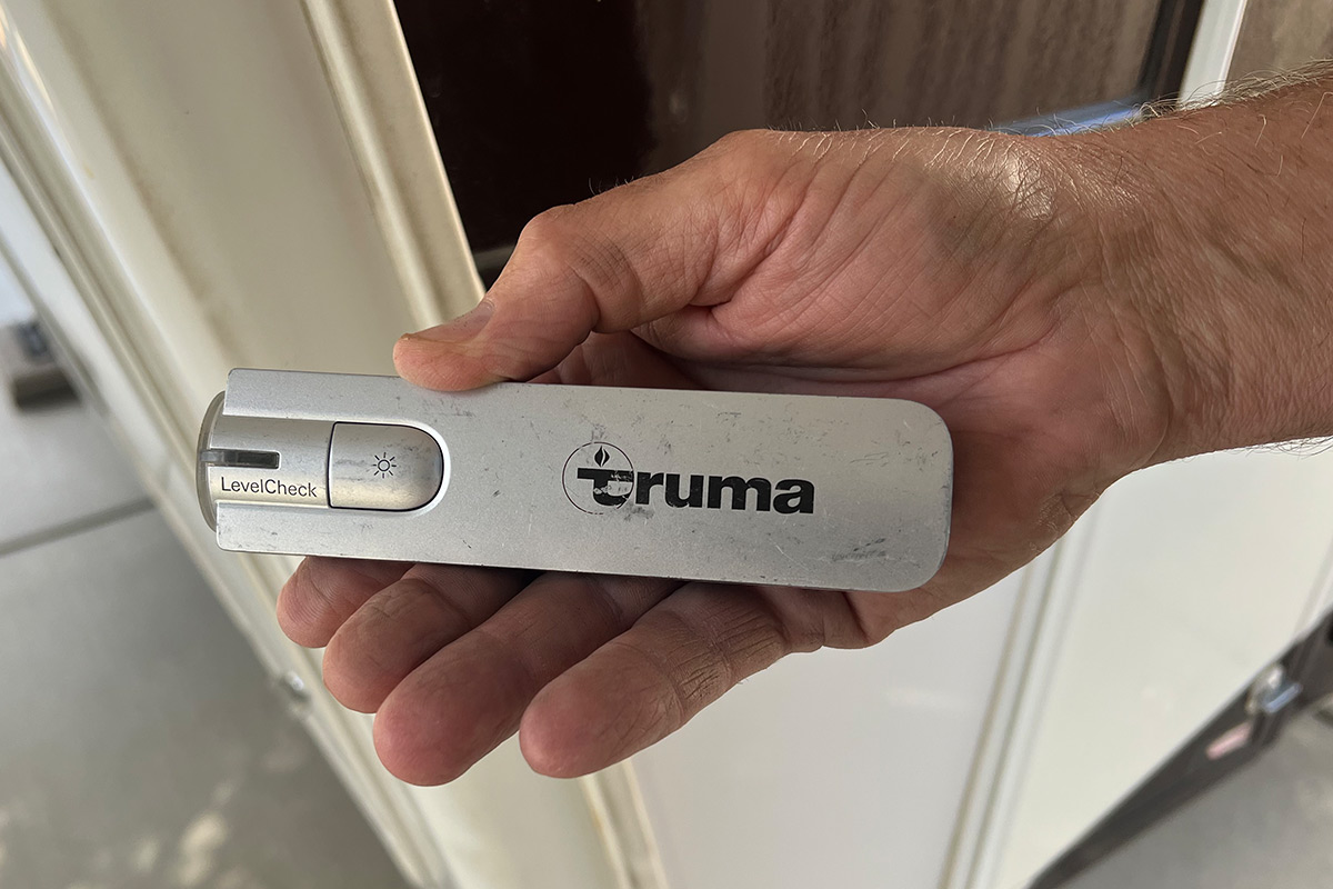 a hand holds the Truma LevelCheck device