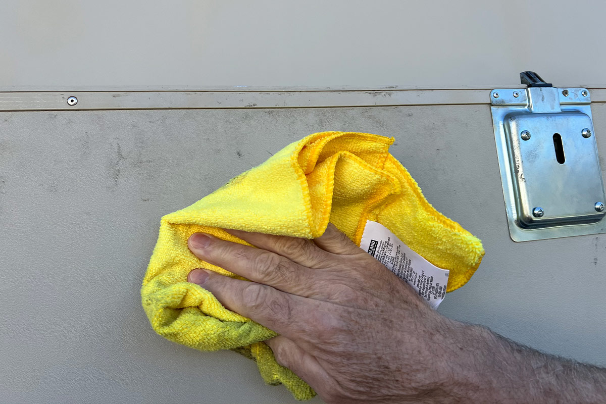 a microfiber towel is used to spot clean an area on the exterior of an RV