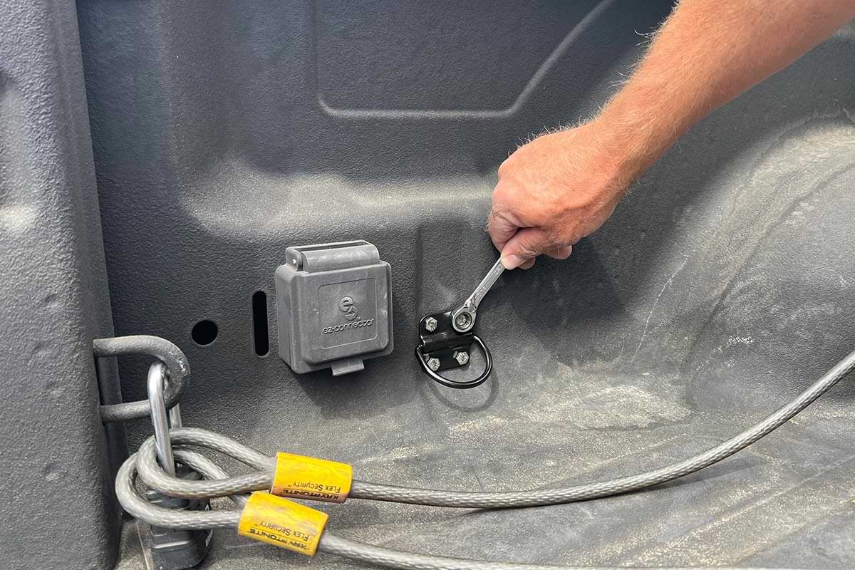 a nut on the tie-down anchor is tightened from the inside of the truck bed