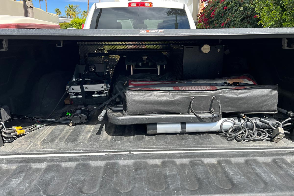 close view of a truck bed with many items of different sizes neatly organized and secured with black straps