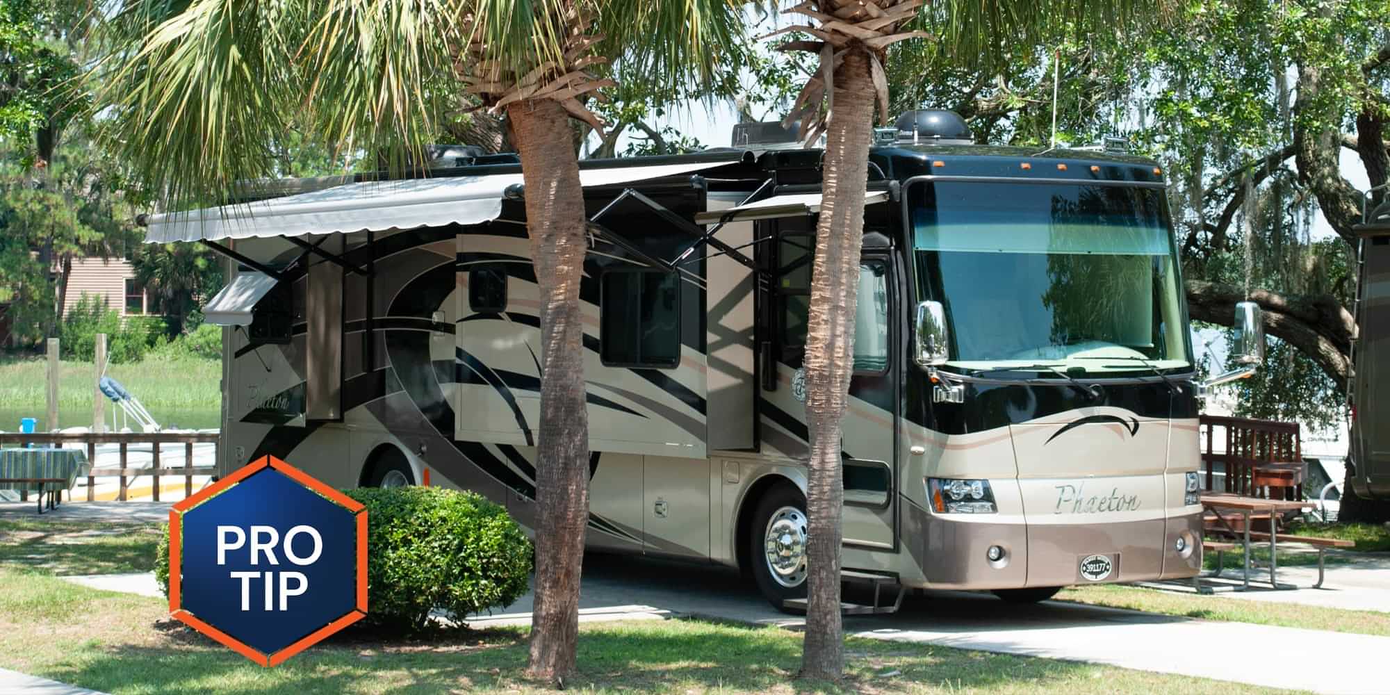 full view of a detailed RV parked near palm trees