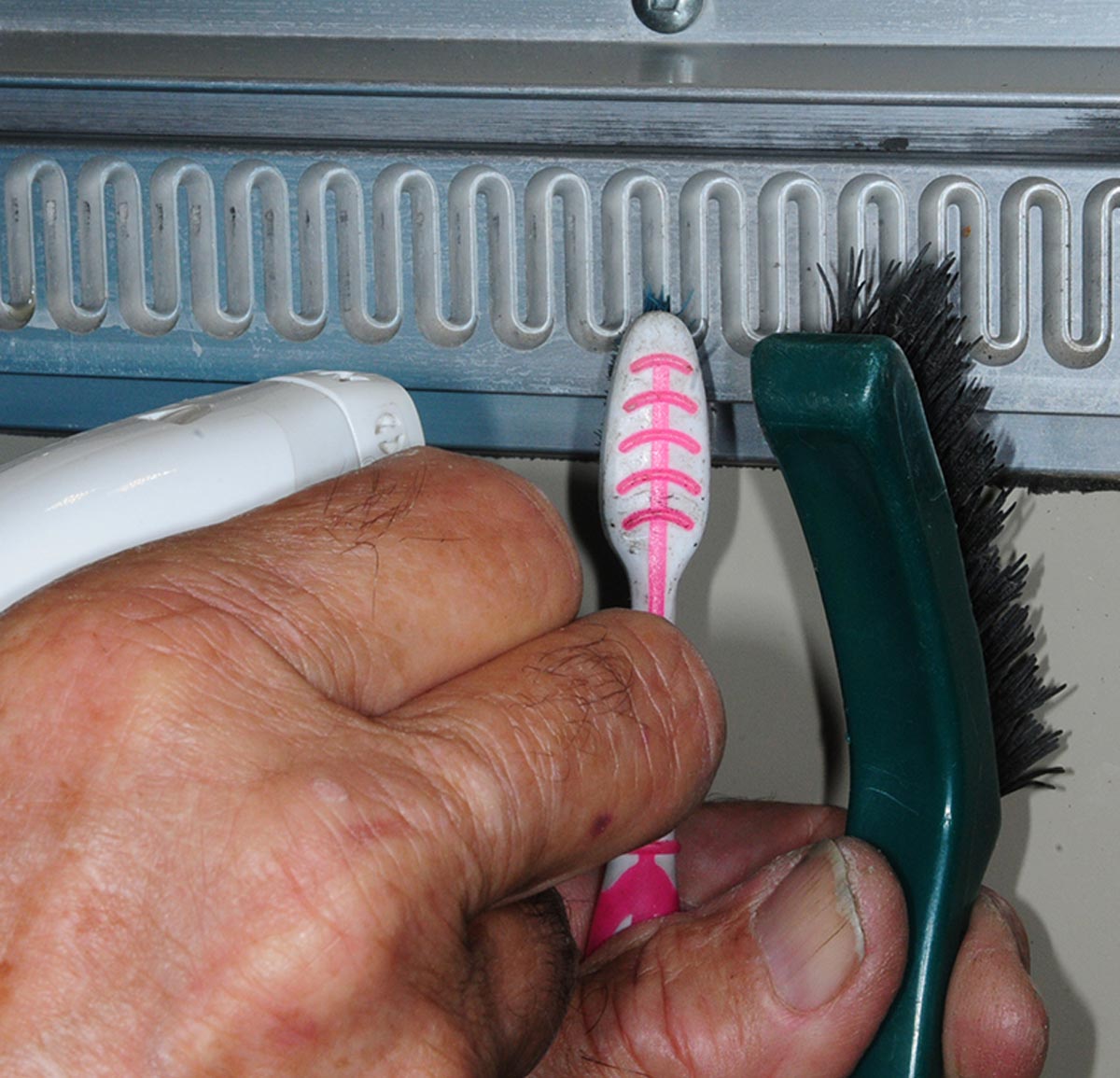 using a tooth brush to clean lower gear racks