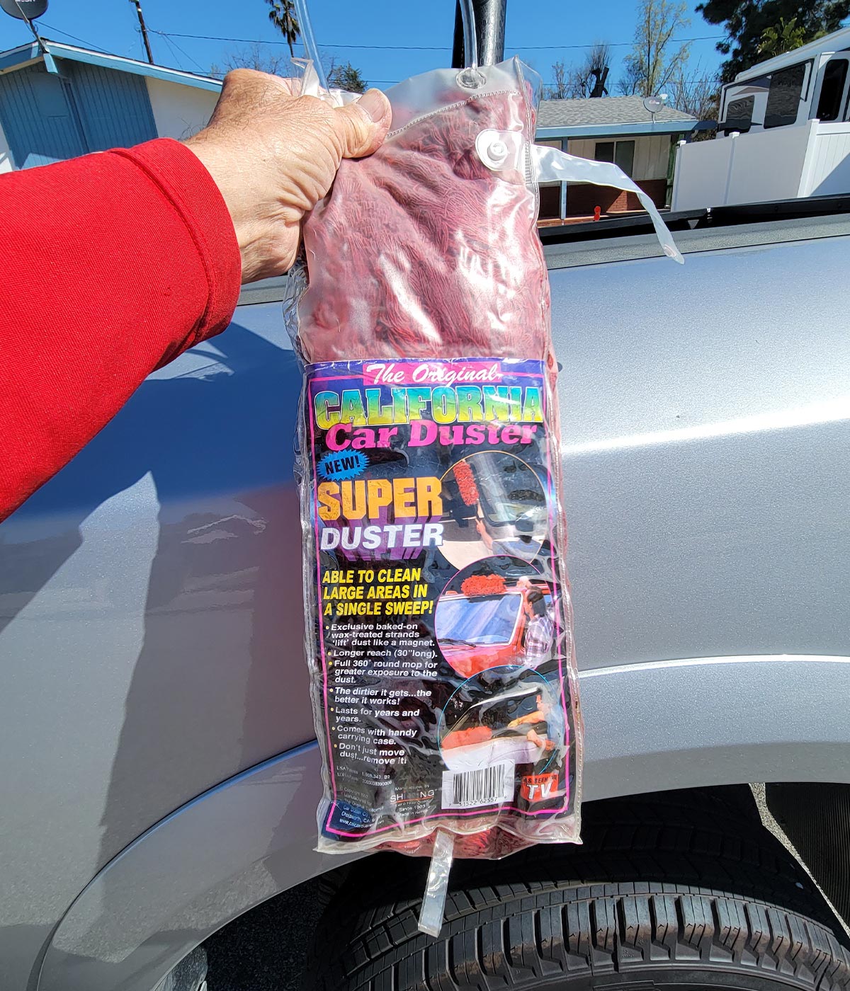 a hand holds up Original California Car Super Duster in its packaging