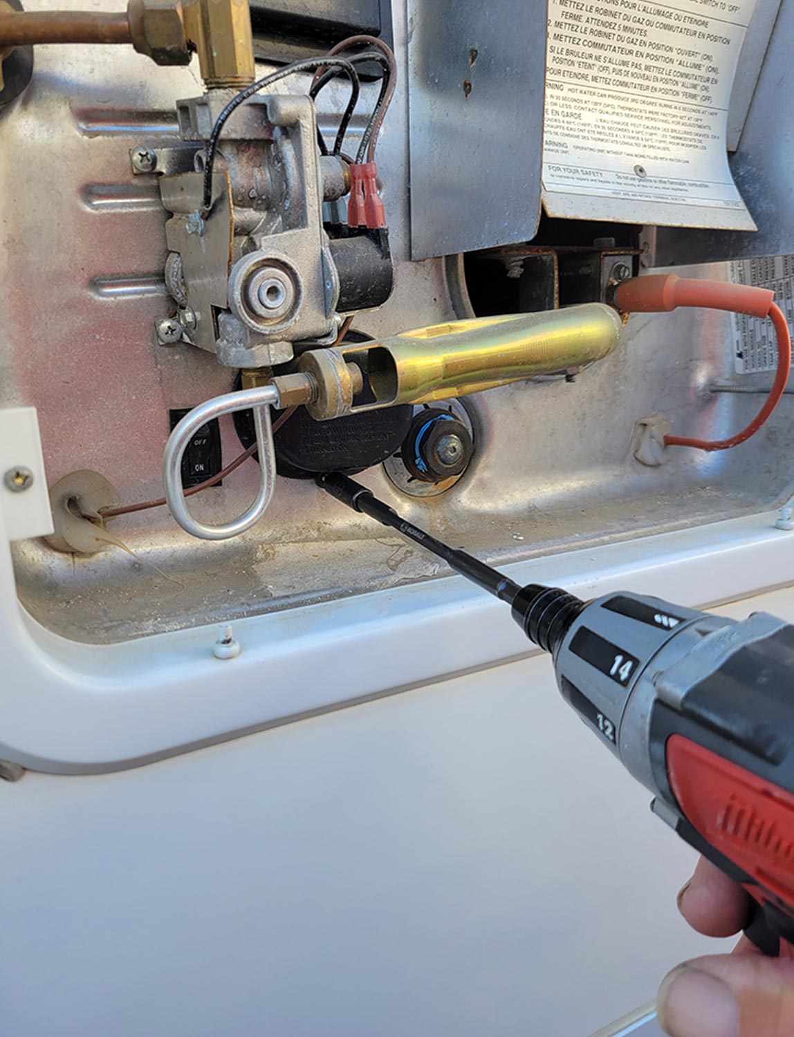 a drill gun is used to remove a screw from the heating element cover