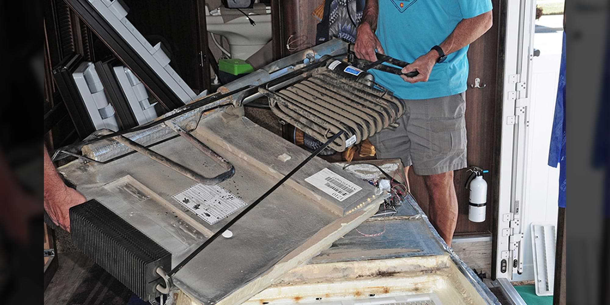 a cooling unit on the fritz being removed from an old refrigerator