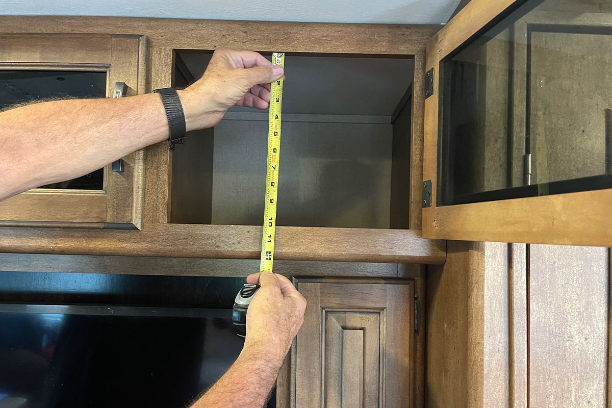 measuring tape is used to determine the height of the RV overhead cabinet