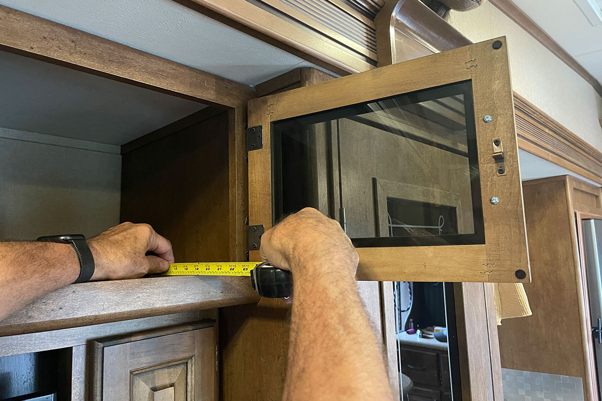 measuring tape is used to determine the depth of the RV overhead cabinet