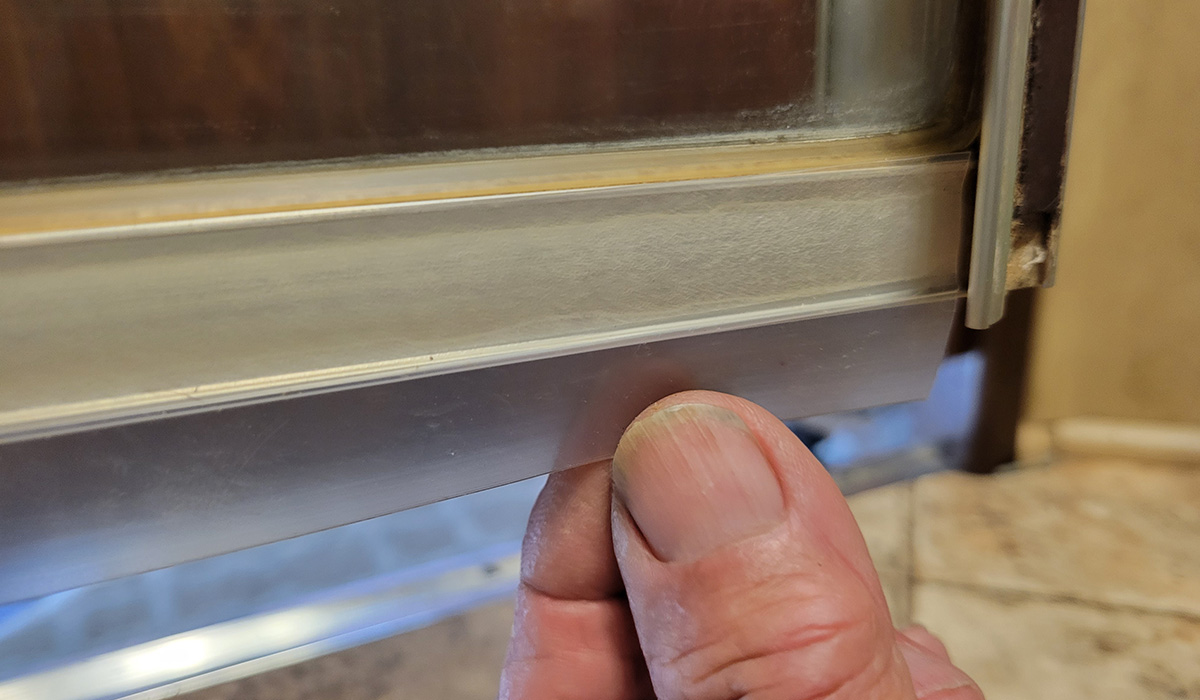 close view of the new 3M seal strip adhered to the bottom of the shower door