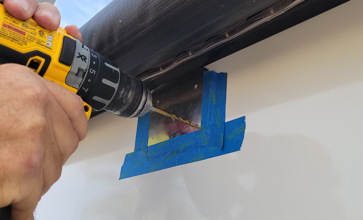 with a pre-punched hole on the backing plate used as a template, holes are drilled into the RV sidewall