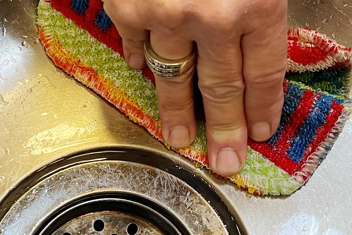 close view a Skoy Scrub pad is used to clean a stainless-steel sink