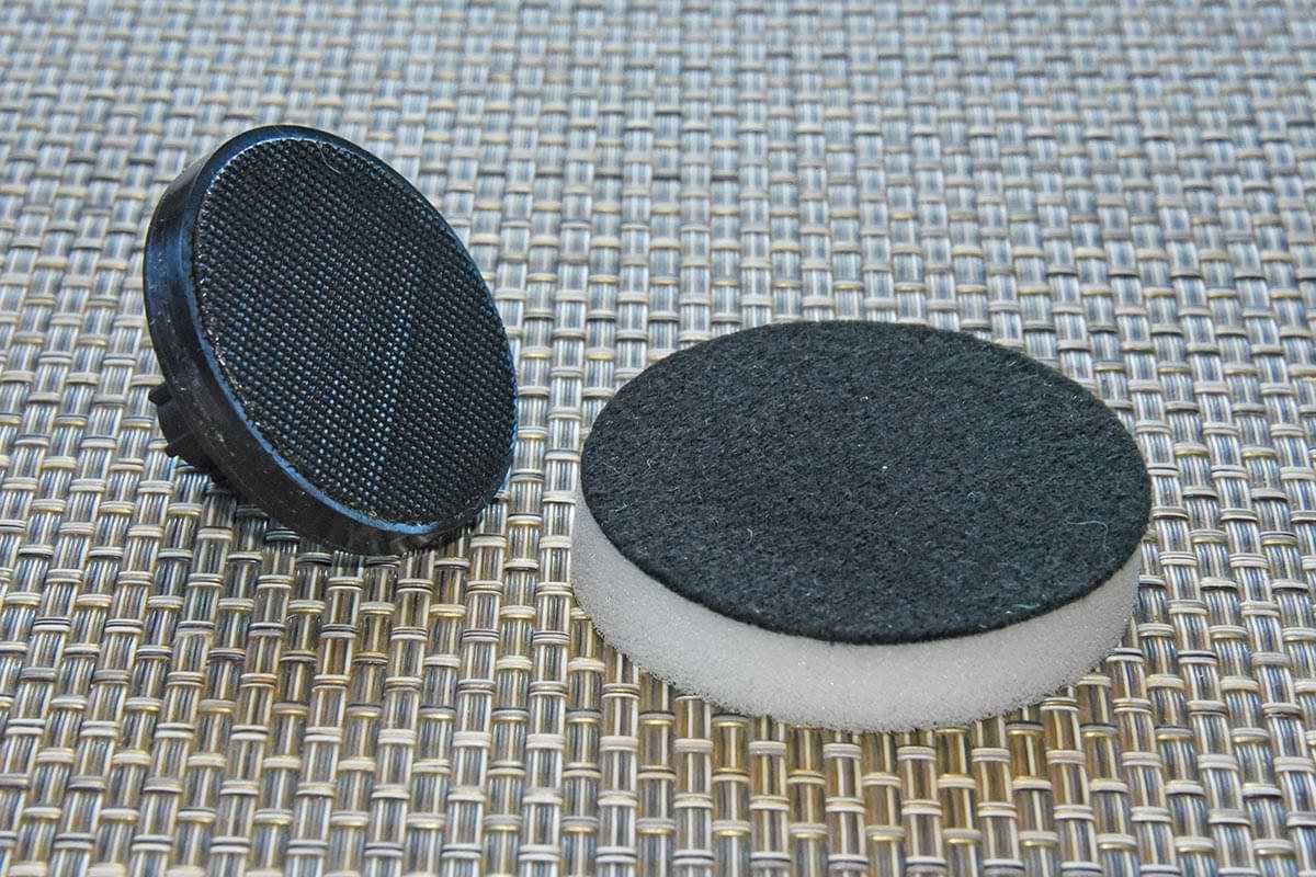 two of the three different pads that come in the Dremel Versa kit on a surface